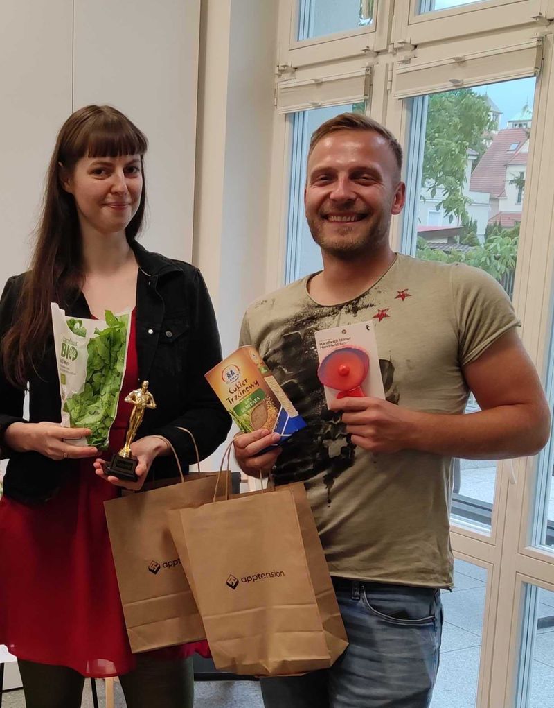 Two people holding awards they just won at Apptension office